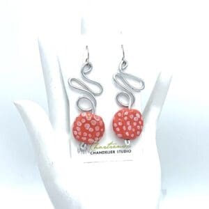 Red polka dot earrings on display stand.