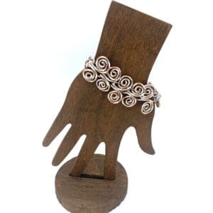 Wooden hand displaying a spiral bracelet.